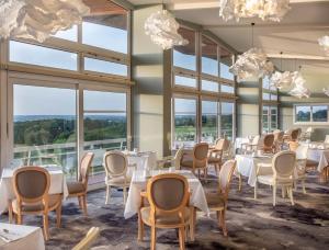普利涅诺特雷达米Domaine des Dryades的用餐室配有桌椅和大窗户
