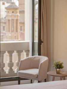 萨拉戈萨东方酒店的窗前的白色椅子
