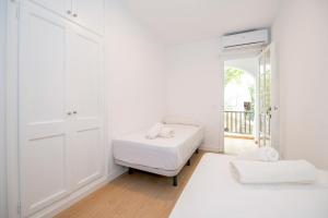 卡拉恩波特Siesta Mar Private Apartments的白色的客房设有床和窗户。