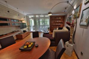 贝尔格莱德Luxurious apartment in Belgrade的一间带木桌的客厅和一间带沙发的客厅。