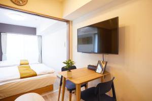 东京SG Premium KASAI的一间卧室配有书桌、一张床和电视。