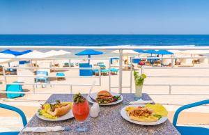 库塞尔Akassia Swiss Resort的海滩上一张桌子,上面放着两盘食物