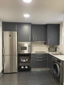 瓦伦西亚Majestic Flats的厨房配有灰色橱柜和不锈钢冰箱