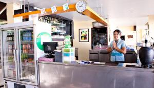 芭东海滩C & N Resort and Spa - SHA Extra Plus的站在餐厅柜台后面的人
