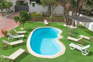 马贝拉Villa Costa Marbella的享有带躺椅和躺椅的游泳池的顶部景致