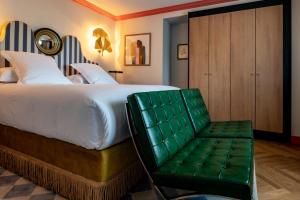 FiacChâteau de Fiac - Luxurious Hôtel & Spa的一间卧室配有一张大床和一张绿色椅子