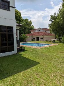 Kampong Alor GajahSerene Holiday Chalet with pool in a quiet enclave的一座带游泳池的房屋的后院