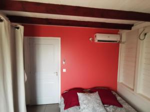 勒迪亚芒LE DIAMANT Charmante Villa pour la famille ou entre amis SPA et Piscine的卧室设有红色墙壁和白色门