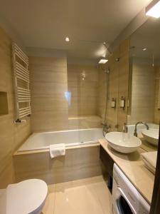 华沙铂金公寓的带浴缸、盥洗盆和卫生间的浴室