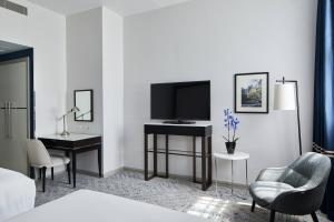 伦敦万豪伦敦格罗夫纳广场酒店的酒店客房配有电视、书桌和椅子。