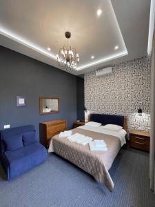 敖德萨Levanevsky Hotel的一间卧室配有一张大床和一张蓝色的沙发