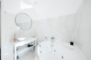 阿维尼翁Les Précieuses Suites & Spa II的白色的浴室设有浴缸和镜子