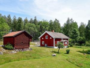 Hjortkvarn16 person holiday home in P LSBODA的田野中的红谷仓和红房子
