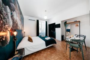 阿维尼翁Les Précieuses Suites & Spa II的一间卧室配有一张床、一张桌子和一张桌子
