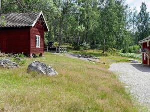 Hjortkvarn16 person holiday home in P LSBODA的一座红谷仓,位于建筑物旁边的田野上