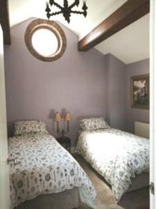 Rushton SpencerThe Jewel in the Crown, countryside escape的一间卧室设有两张床,墙上设有一面镜子