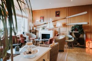 罗斯科夫Hôtel Aux Tamaris - Vue Mer的客厅配有桌椅和壁炉