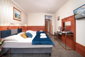弗瓦迪斯瓦沃沃Hotel Rejs的一间卧室配有一张带蓝色毯子的大床