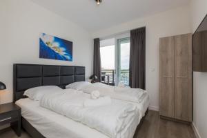 圣安娜兰Appartement Vista Maris, Havenweg 8-4, Sint Annaland的一间卧室设有两张白色的床和窗户
