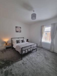 巴罗弗内斯Highly Modern home, 3 bed, close to the Lake District的白色的卧室设有床和窗户