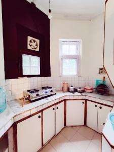 西姆拉Home away from home , Perfect Family set !的厨房配有白色橱柜和炉灶。