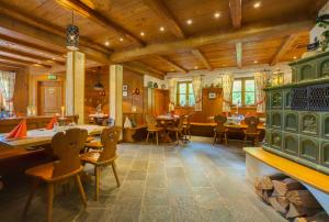格赖瑙Berghotel Hammersbach的用餐室设有桌椅和木制天花板