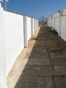 蓬塔翁布里亚El Chalet的一条长长的人行道,旁边是白色的墙壁