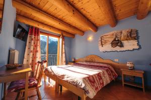 泰穆贝罗提农家乐的一间卧室配有一张床、一张桌子和一个窗户。