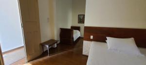 圣若昂-德雷玉兰别墅旅馆的一间卧室配有一张床、一把椅子和镜子