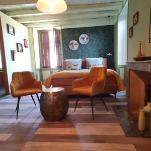 MelleMaison Fossemagne的一间卧室配有一张床和两张橙色椅子