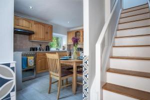 斯旺西Wern Y Glais - 2 Bedroom Cottage - Glais的厨房设有木桌和楼梯。