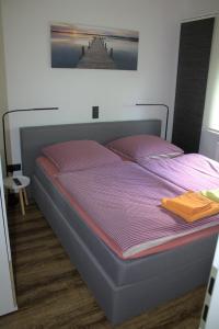 维林根Ferienhaus Bergliebe I in Willingen-Usseln的一间卧室配有一张带紫色棉被的床