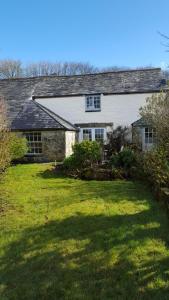卡姆尔福德Mayrose Cottage, Charming Cornish Cottage for the perfect escape...的一座带草地庭院的古老石头房子