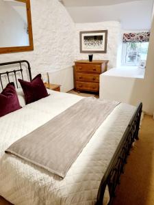 卡姆尔福德Mayrose Cottage, Charming Cornish Cottage for the perfect escape...的卧室配有白色大床和梳妆台