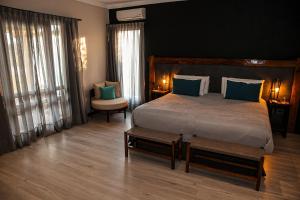 圣拉斐尔阿尔戈栋酒庄冠军俱乐部酒店的一间卧室配有一张带蓝色枕头的大床