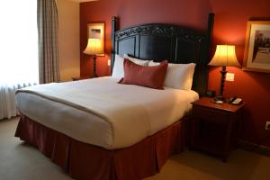 提顿村提顿俱乐部酒店的一张大床,位于酒店带两盏灯的房间