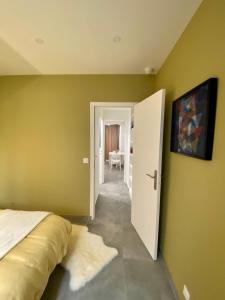 巴黎Chez les artistes de Ménilmontant的一间卧室设有绿色的墙壁、一张床和一扇门
