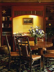 提顿村提顿俱乐部酒店的一间带桌椅和鲜花的用餐室