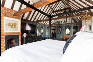 莫尔登Staycations Maldon的卧室配有白色的床和壁炉