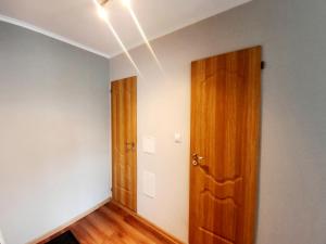里加Light Apartment的一间空房间,设有木门和白色的墙壁