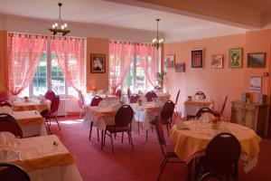 维耶尔宗Le Chalet de la Foret Logis Hôtel 3 étoiles et restaurant的用餐室设有桌椅和窗户。