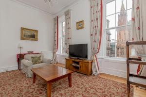 爱丁堡St James Quarter 2 Bed Apartment的客厅配有电视、沙发和桌子