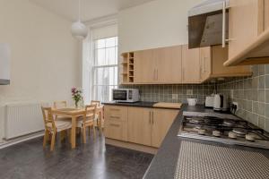 爱丁堡St James Quarter 2 Bed Apartment的厨房配有木制橱柜和桌椅