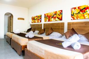 圣罗莎德卡瓦尔Hotel Plaza Real的酒店客房 - 带三张床和毛巾