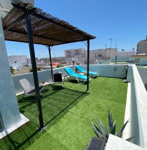 加的斯Apartamentos El BALNEARIO by Cadiz4Rentals的一个带草地和草伞的屋顶露台
