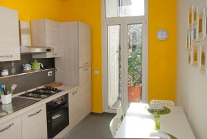 罗马欢朋迎宾公寓的厨房设有黄色的墙壁、炉灶和窗户。