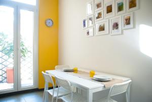 罗马欢朋迎宾公寓的一间配备有白色桌椅的用餐室