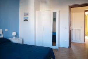 罗马欢朋迎宾公寓的一间卧室配有蓝色的床和镜子