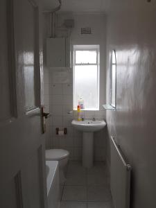 伦敦帕丁顿公寓的一间带水槽和卫生间的浴室以及窗户。