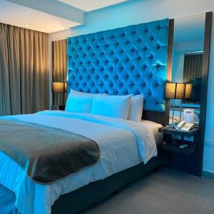 波拉马尔Tibisay Hotel Boutique Margarita的蓝色卧室,配有一张大床和蓝色床头板